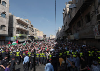 AMMAN, JORDAN - OCTOBER 13: Jordanian protesters march at the downtown in front of the Husseini Mosque, raising the Jordanian and Palestinian flags, demanding an end to the Israeli aggression on the Gaza Strip and the protection of civilians, on October 13, 2023, in Amman, Jordan. On October 7, the Palestinian militant group Hamas launched the largest surprise attack from Gaza in a generation, sending thousands of missiles and an unknown number of fighters by land, who shot and kidnapped Israelis in communities near the Gaza border. The attack prompted retaliatory strikes on Gaza and a declaration of war by the Israeli prime minister. (Photo by Jordan Pix/ Getty Images)