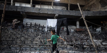 A displaced Palestinian girl walks inside the auditorium in the heavily damaged Islamic University campus where Palestinian families take refuge, in Gaza City, on May 1, 2025. (Photo by Majdi Fathi/NurPhoto via Getty Images)